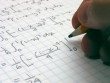 hand holding pencil over graph paper with calculus calculations writting on it 
