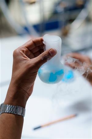 hand holding a rounded science beaker 